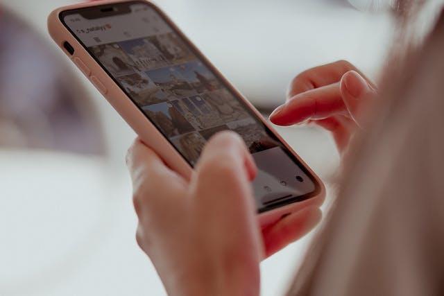 Wanita menjelajahi Instagram di ponselnya