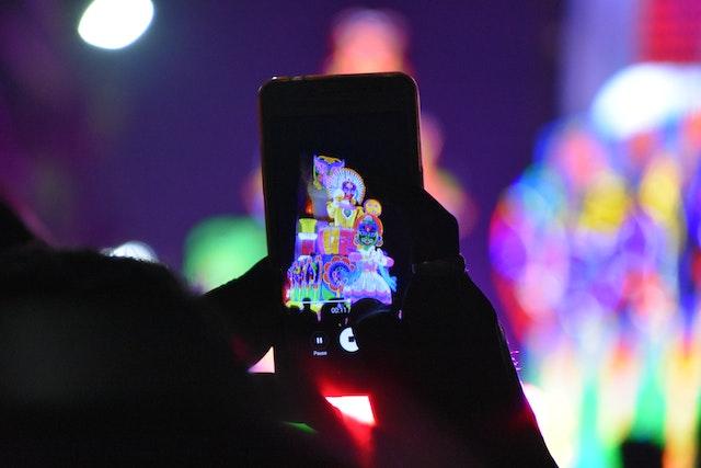 Человек фотографирует телефоном ночью